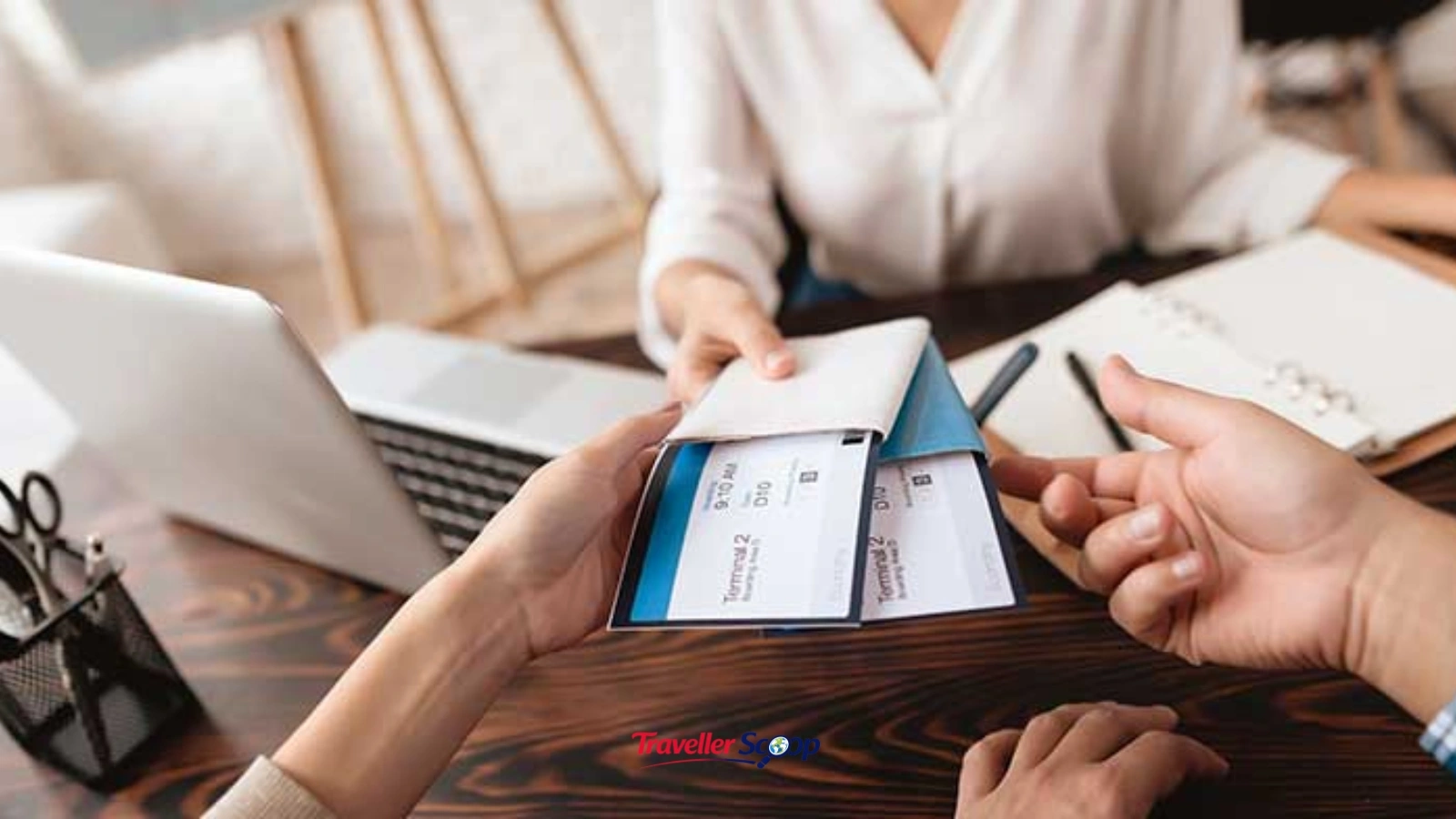 Traveller booking a flight ticket on a laptop with a boarding pass nearby