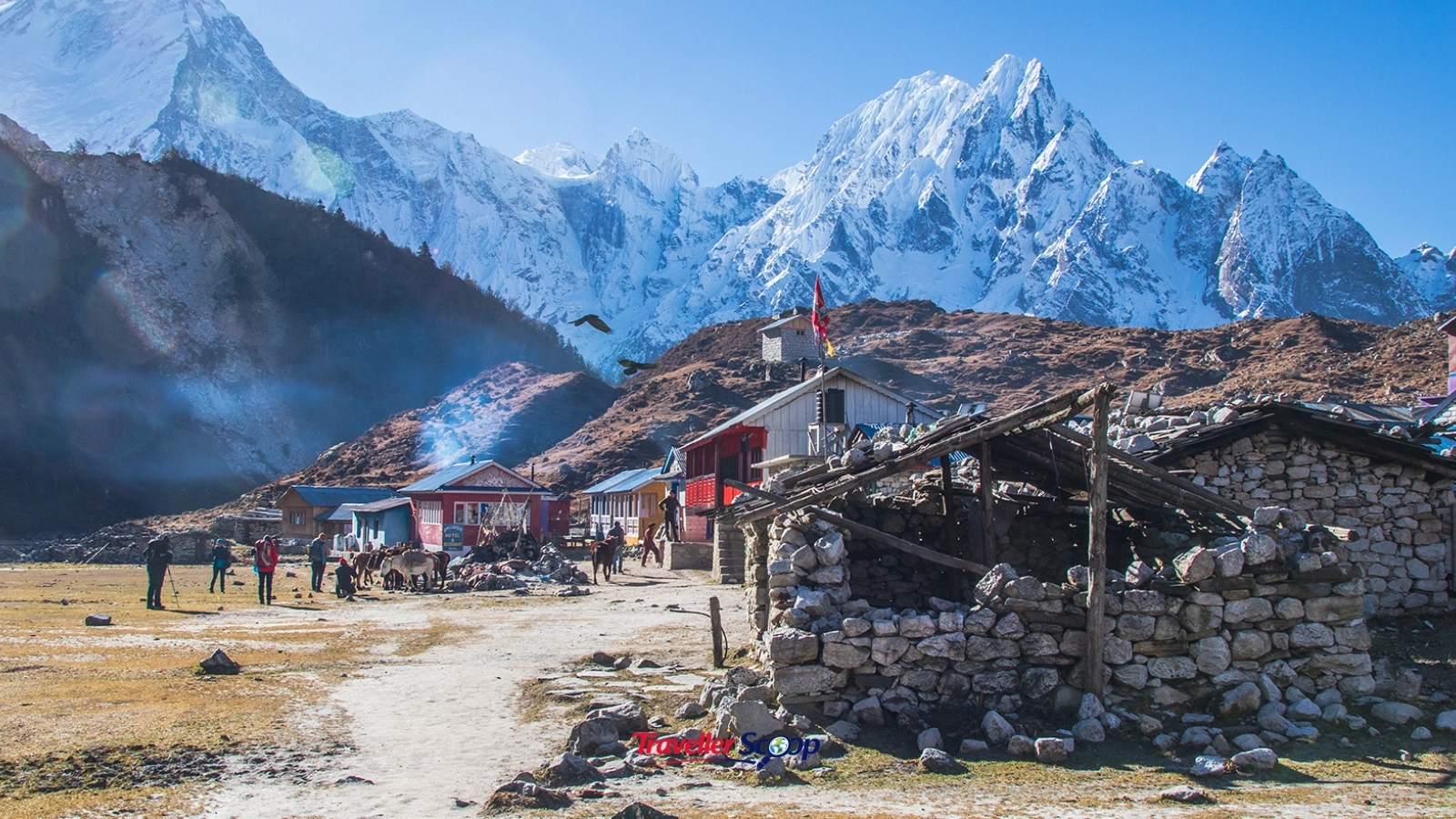 A remote mountain hiking trail with a small stone guesthouse village visible below. A remote mountain hiking trail with a small stone guesthouse village visible below.