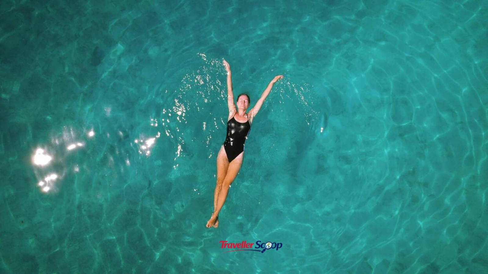 Swimmer entering crystal clear wild swimming lake surrounded by cliffs Swimmer entering crystal clear wild swimming lake surrounded by cliffs
